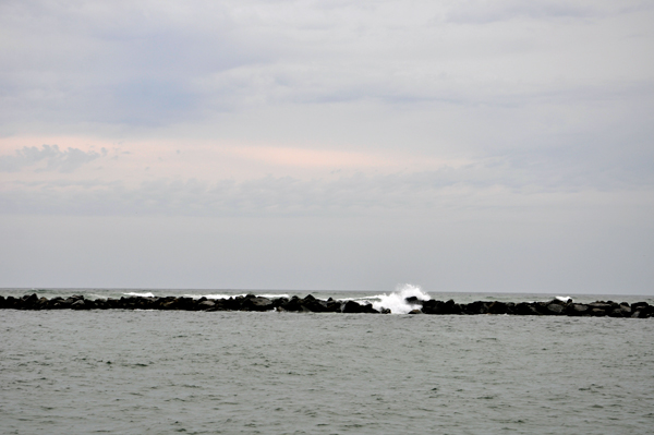 The waves were breaking high over the nearby jetty